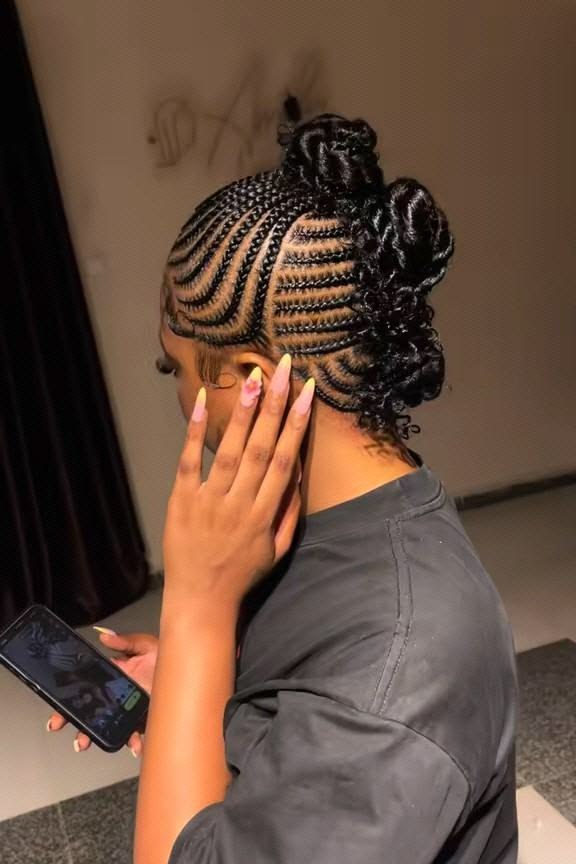 Stylist braiding a client's hair in a salon
